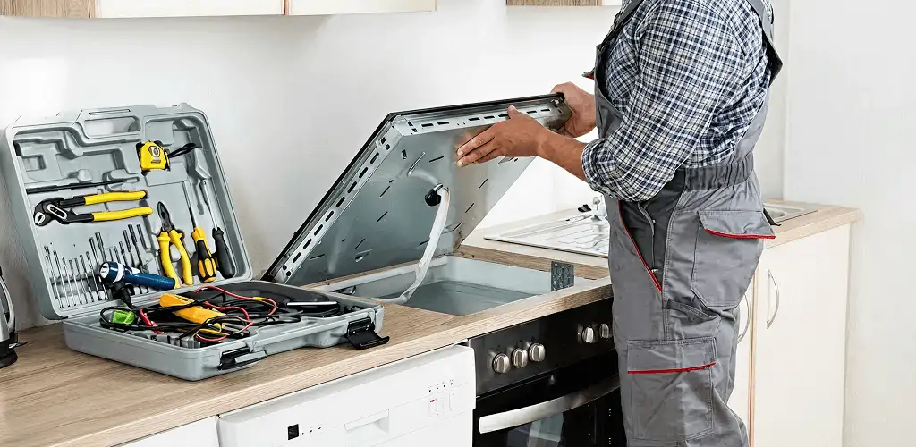 Handyman repairing a cooktop and checking wiring connections in Green Bay, WI