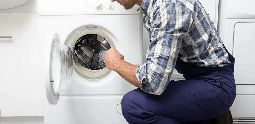 Handyman inspecting a dryer drum and internal parts for repair in Green Bay, WI