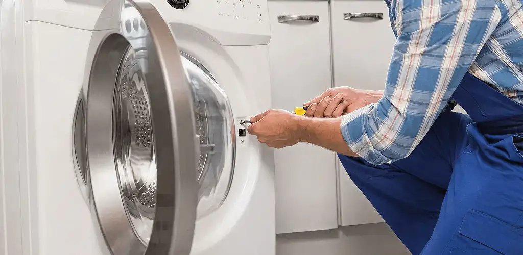 Handyman repairing a clothes dryer and checking electrical connections in Green Bay, WI
