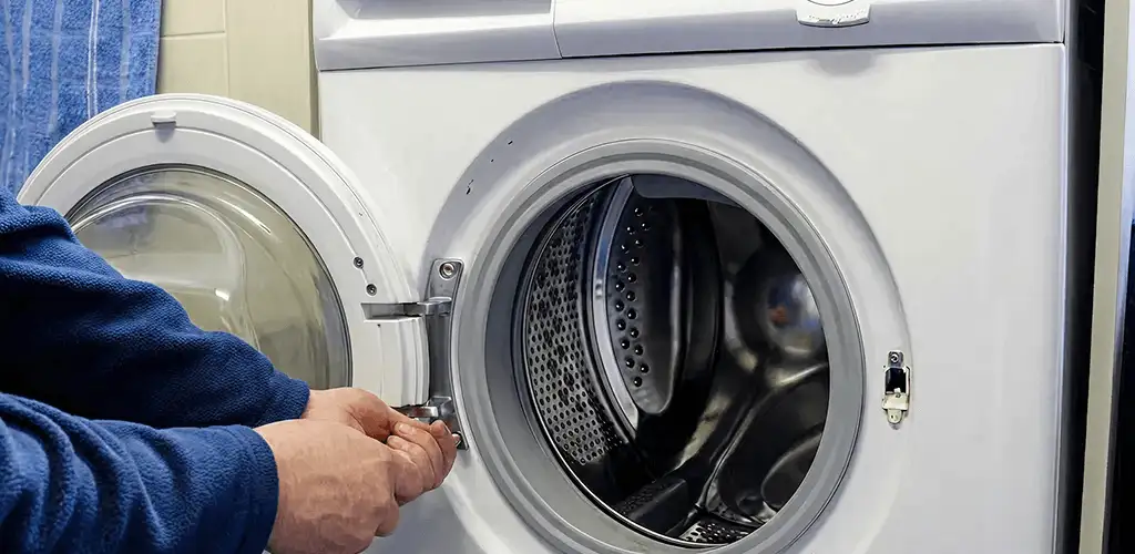 Washing machine repair handyman checking a front-load washer door and latch in Green Bay, WI