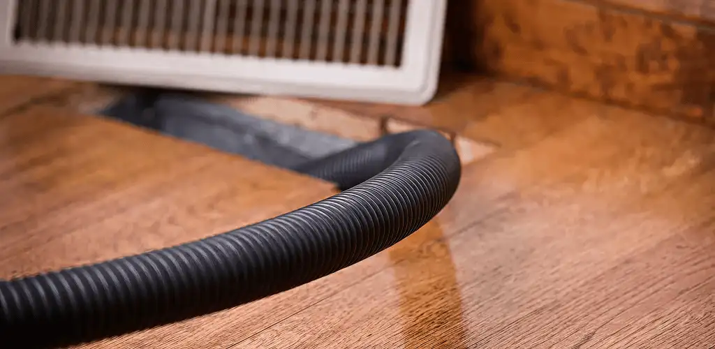 Air duct cleaning hose inserted into a floor vent for ductwork cleaning in Green Bay, WI